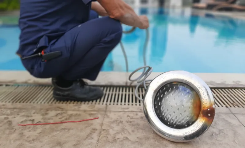 Electrician repairing burnt out pool light